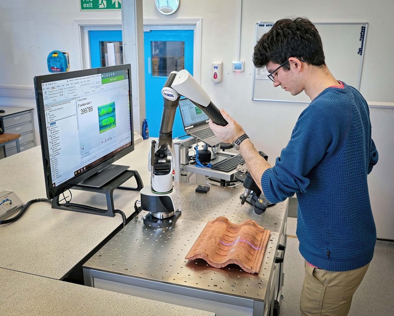 Luke Kelly usando el brazo LK FREEDOM y el escáner de línea láser Nikon para inspeccionar una teja de concreto en la sala de metrología del Centro Técnico de BMI