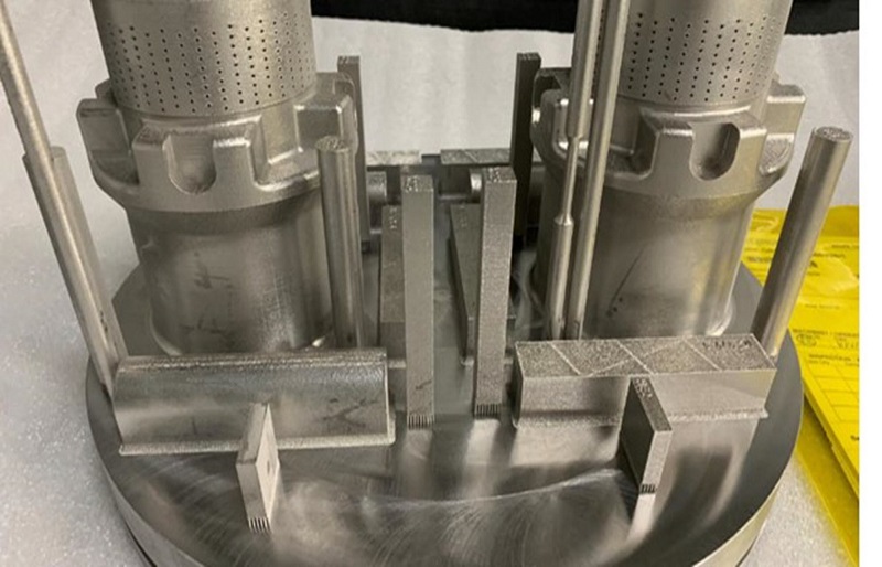 Dos válvulas de estrangulamiento, optimizadas con la tecnología DRAG de IMI, mostradas en la placa de construcción después de ser impresas en 3D con el sistema Sapphire de VELO3D